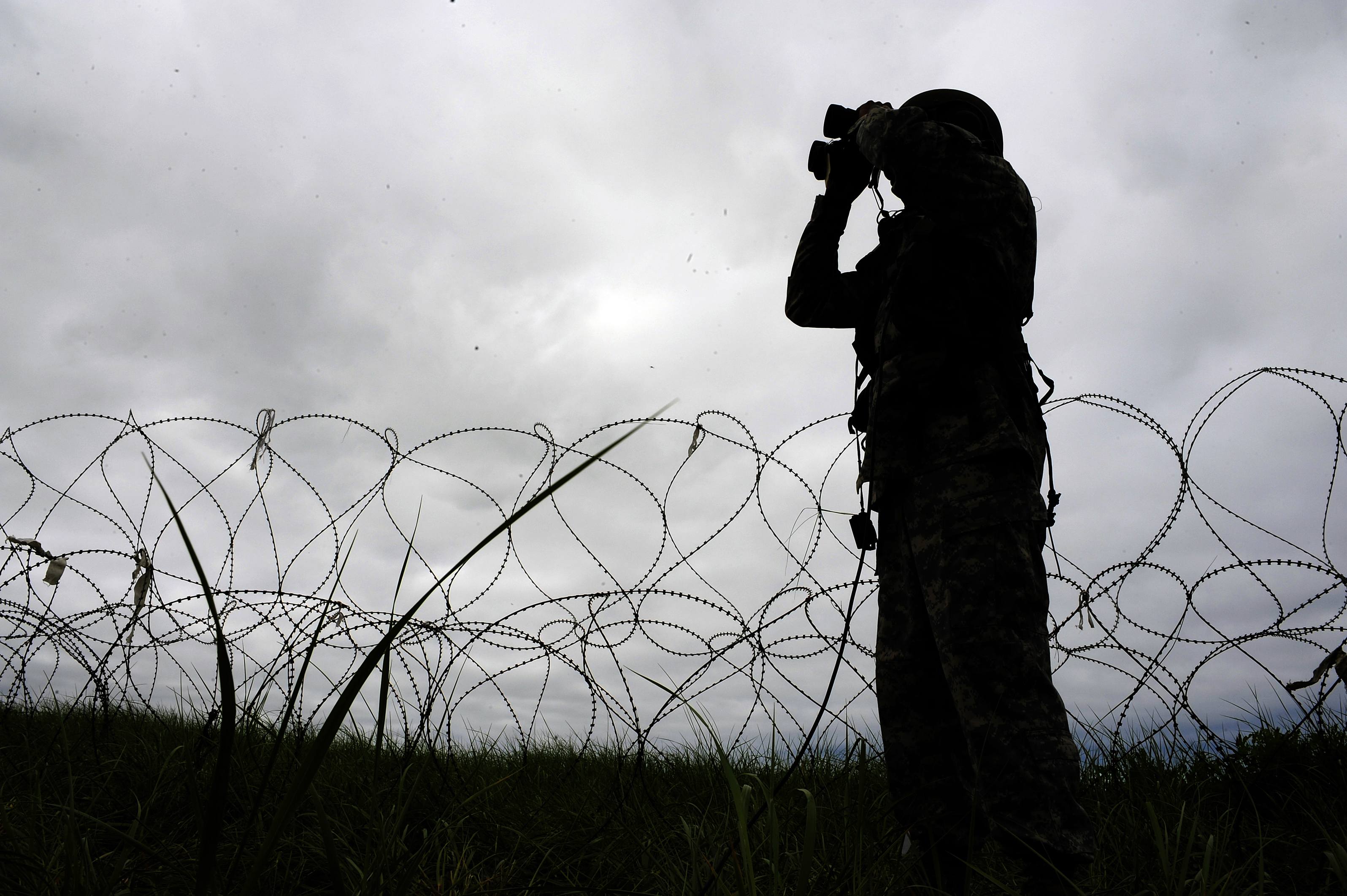 A soldier searching through binoculars
